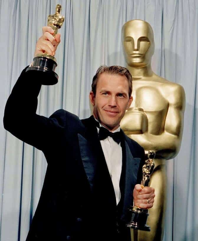 Kevin Costner holding multiple awards