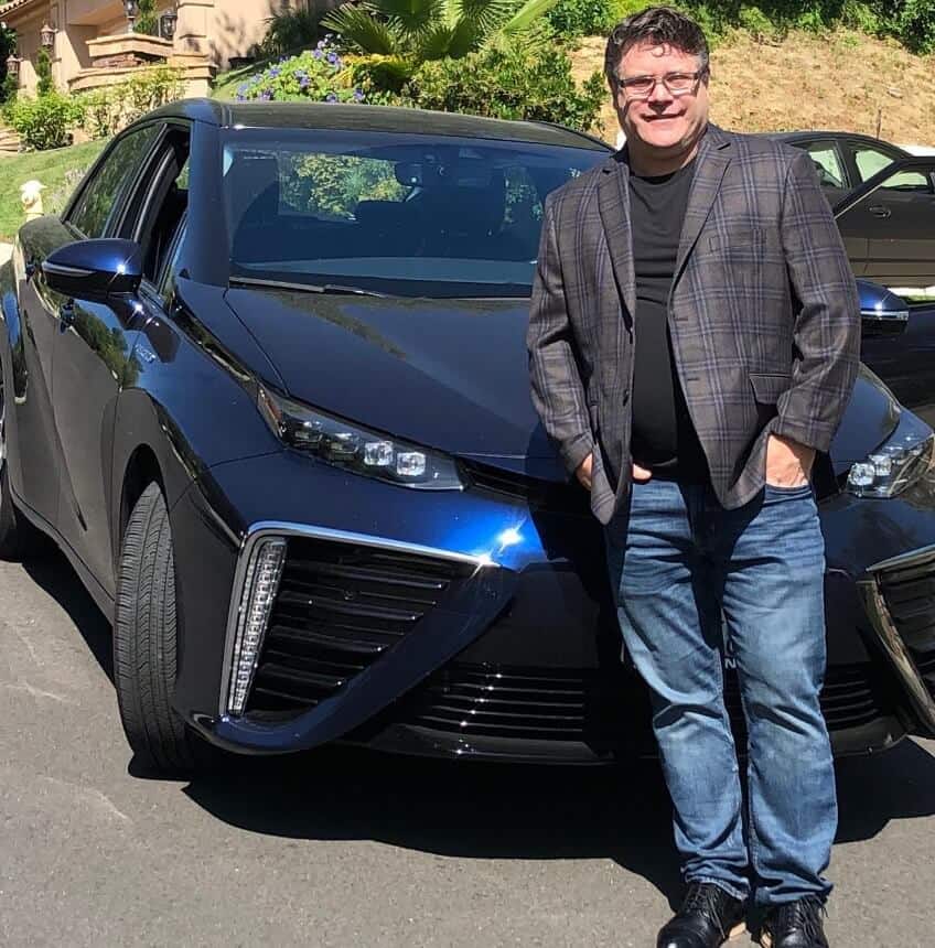 Sean Astin posing in front of car