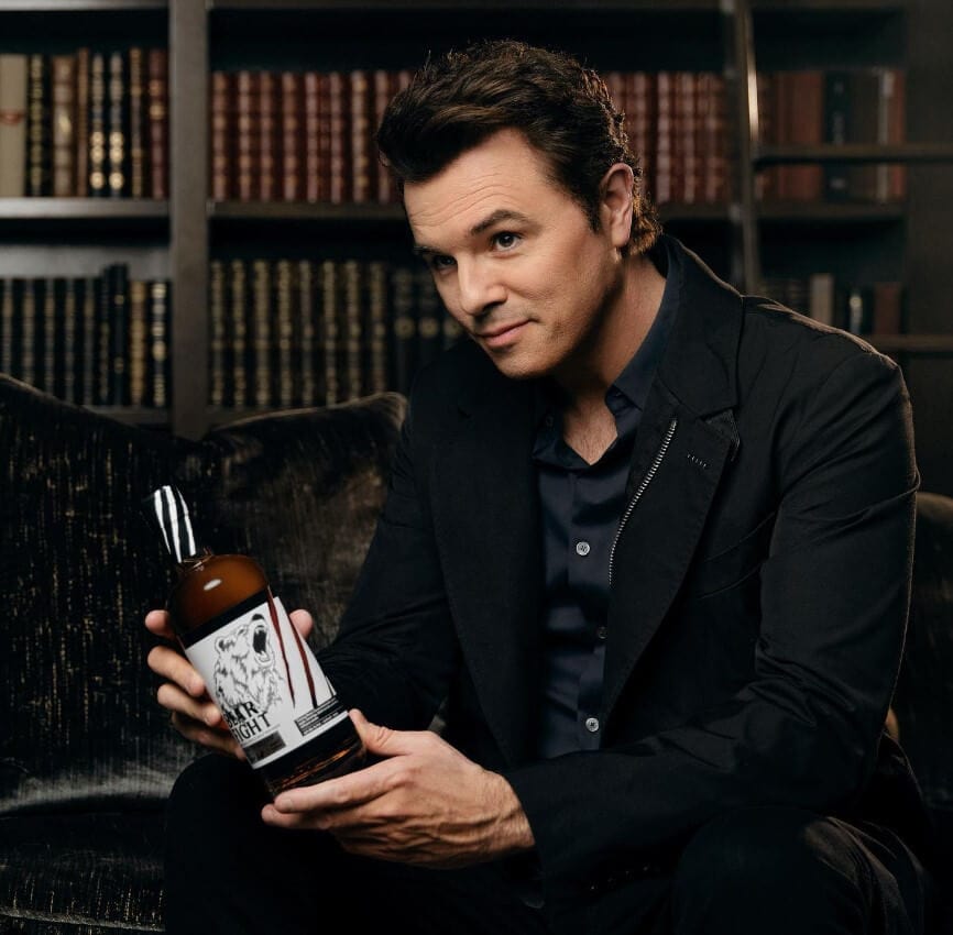 Seth MacFarlane holding whiskey bottle