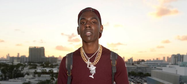 Young Dolph posing from flyover bridge