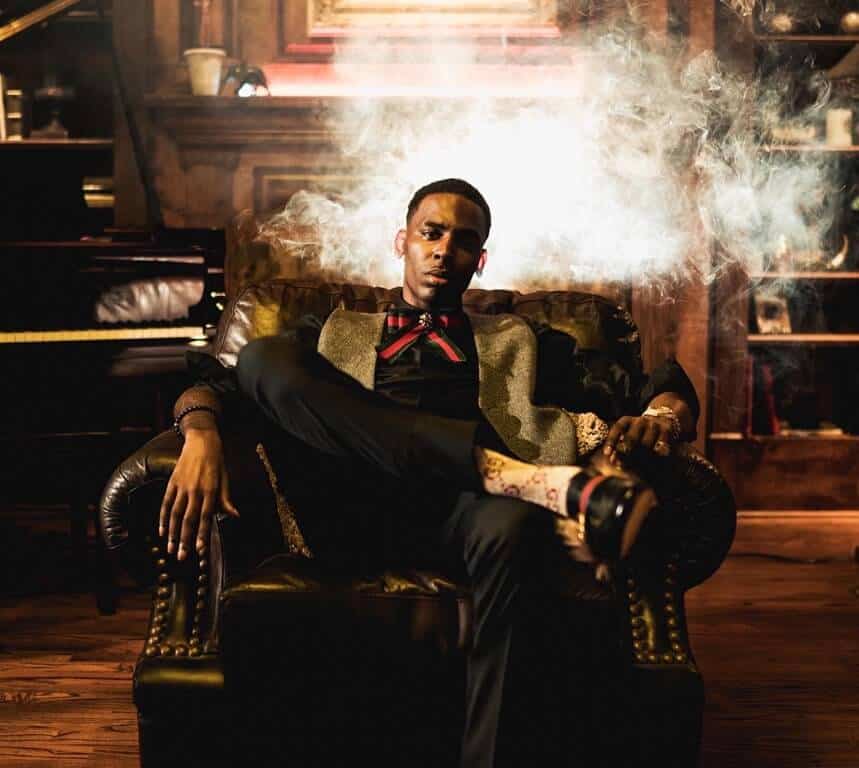 Young Dolph sitting on sofa